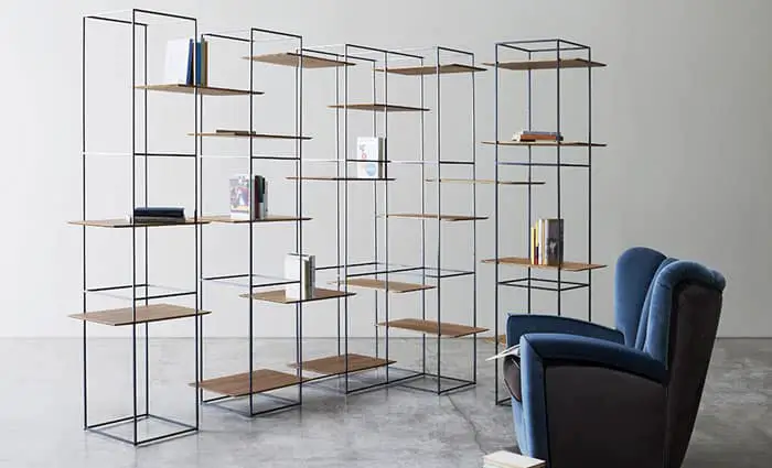 Ron Gilad 's TT3 shelving system consists of several tall single columns and a corner unit with rectangular shelves in Italian walnut.