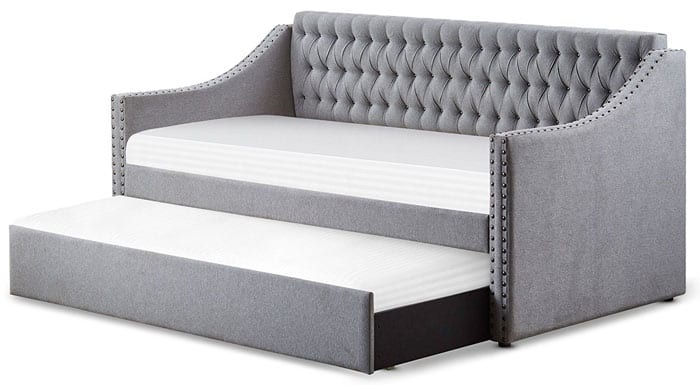 The beautiful Tulney Daybed with tufted cushions and nailhead accents has a trundle that slides out to reveal a guest bed.