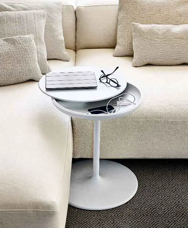 The Toi / 632 round table top wings out to reveal hidden storage space underneath. The table slides easily under the sofa when you don't have room for a coffee table. 