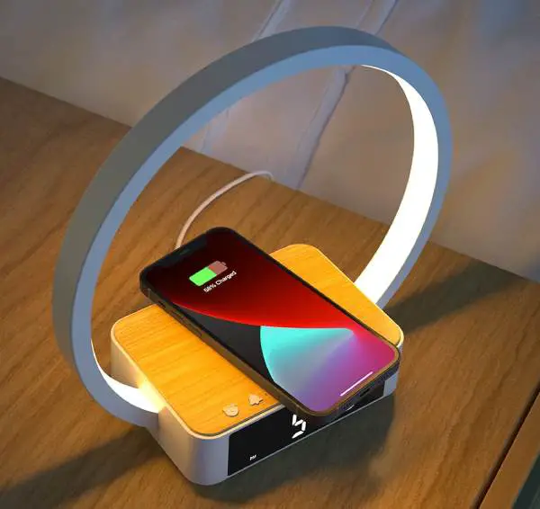 Amouhom table lamp is a wireless phone charging station with a dimmable LED screen and an alarm clock.